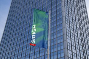 Waving banner that says Headis, in front of a skyscraper